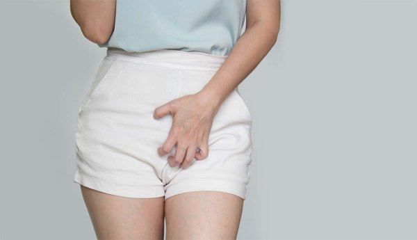 foto mostrando uma mão em posição de coçar, próximo a área íntima feminina